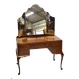 A mid-20th century mahogany knee holed dressing table with triptych mirror back, raised on
