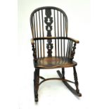A 19th century elm seated Windsor rocking chair with crinoline stretcher.
