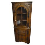 A good quality reproduction oak freestanding flat fronted corner cabinet, with single glazed door
