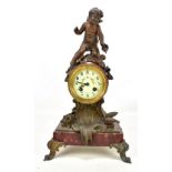 A late 19th century French bronzed metal mounted red hardstone mantel clock with cherub finial,