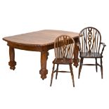 A large oak extending dining table with carved detail on turned and block supports to castors,