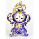 A late 19th century French porcelain floral painted gilt heightened mantel clock, the circular white