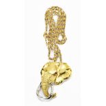 An 18ct textured yellow gold pendant in the form of an elephant's head, with ruby for eye and