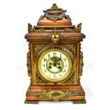 A late 19th century oak cased bracket clock with applied brass filigree decoration, the circular