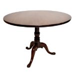 A 19th century mahogany circular tilt top table on turned column to three legs terminating in pad
