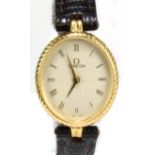 WITHDRAWN OMEGA; a lady's yellow metal cased quartz dress watch, the oval dial set with Roman