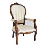 A Victorian style stained beech spoon back open armchair, recently reupholstered, on cabriole legs.