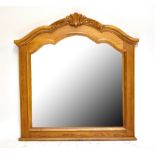 A reproduction carved oak wall mirror with arched top, height 115cm.
