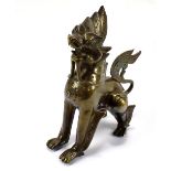 A Tibetan bronze model of a dog set with 'jewels', height 21.75cm.