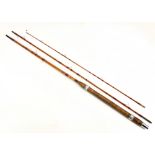 A vintage three piece split cane fishing rod signed 'Wallis' in a Hardy canvas sleeve.