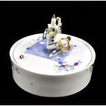 MEISSEN; a 20th century circular lidded box surmounted with a seated juggling harlequin designed
