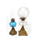 Two early 20th century oil lamps, one with frosted glass shade, height of largest example 57cm (2).