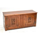 A reproduction oak blanket box with two faux panelled doors, raised on block supports, width 142cm.