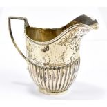 A George V hallmarked silver helmet shaped cream jug with part gadrooned body, Birmingham 1921,
