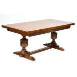 An oak draw leaf refectory table with carved floral frieze on turned stretched supports, 77 x