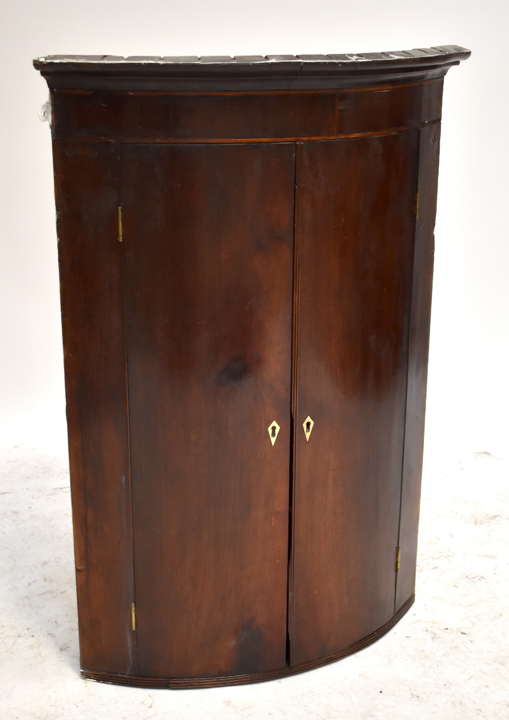 A George III mahogany bow front twin door corner cupboard, 101  x 71cm.Additional