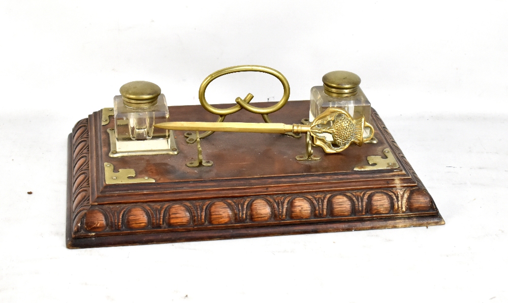 An early 20th century oak desk stand with silver plated mounts, length 38cm, and a brass letter