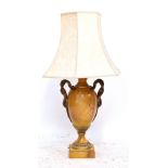 An imitation yellow hardstone urn shaped table lamp with gilt metal mounts and twin handles modelled