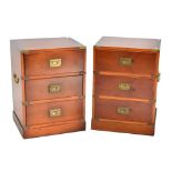 A pair of reproduction mahogany veneered campaign style chests of three drawers with brass side