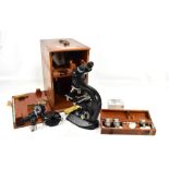 A cased Cooke binocular microscope with various accessories, lenses, etc.