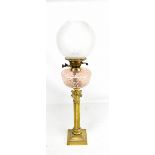 A Victorian brass Corinthian column oil lamp with pink reservoir, height 79cm.Additional