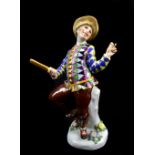 MEISSEN; a 19th century figure of a clown holding a slap stick, blue painted crossed swords mark