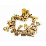 A 9ct yellow gold charm bracelet set with numerous charms including a pistol, accordion, Noah’s ark,