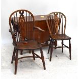 A 1920s/30s oak drop leaf gateleg dining table on barley twist supports with a set of seven elm