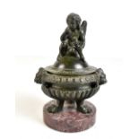 A bronze Renaissance style Grand Tour inkwell with cherubic lid, brass liner and raised on a