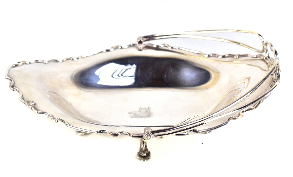 A George V hallmarked silver oval dish with swing handle, with pierced scrolling edge, maker's marks