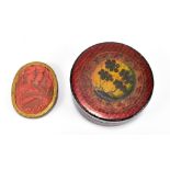 An early 19th century lacquered circular snuff box with painted foliate and gilt detail on