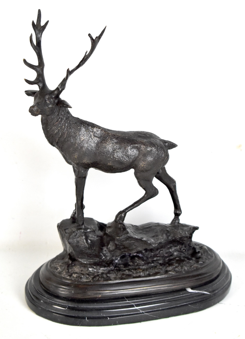 AFTER MENE; a spelter stag stood on rocky outcrop on stepped oval black hard stone base, signed,
