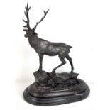 AFTER MENE; a spelter stag stood on rocky outcrop on stepped oval black hard stone base, signed,