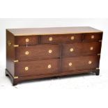 A large campaign-style brass mounted mahogany chest with arrangement of seven drawers on bracket