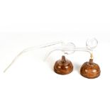 Two clear glass oral breast pumps for self expressing, both mounted on associated turned wooden
