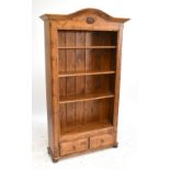 A modern stained pine open fronted bookcase with three adjustable shelves above two base drawers,