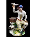 MEISSEN; a rare mid-18th century figure of a harlequin with a bird cage, bird in hand and cat by his