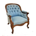 A 19th century walnut framed balloon back armchair with carved detail in light blue upholstery on