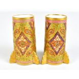 COALPORT; a pair of Cashmere ware cylindrical vases, each with three stepped gilt heightened feet,