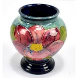 MOORCROFT; a small blue/green ground floral decorated vase, height 8.75cm.