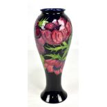 MOORCROFT; a tubeline decorated 'Anenome' pattern baluster vase on dark blue ground, impressed marks