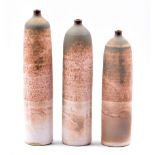 EMILY MYERS (born 1965); a trio of narrow stoneware bottle forms covered in mottled matt pink glaze,