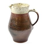 GEORGE COOK (1919-1982); an early stoneware jug covered in kaki glaze with iron spotted grey rim,