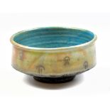 JOHN BEDDING (born 1947); a raku footed bowl covered in turquoise glaze with incised decoration,