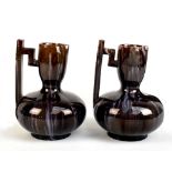 A pair of Linthorpe style ewers with stepped square sectioned handles, pinched spouts and globular