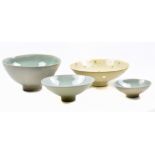 A graduated set of stoneware footed bowls covered in sage green crackle glaze, impressed HK marks,