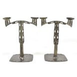 ARCHIBALD KNOX FOR TUDRIC PEWTER AND LIBERTY & CO; a pair of candelabra, with relief and pierced