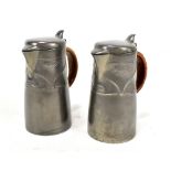 ARCHIBALD KNOX FOR ENGLISH PEWTER AND LIBERTY & CO; a pair of pewter water jugs with basket weave