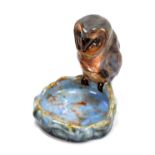 ROYAL DOULTON LAMBETH; a model of a barn owl perched on a blue glazed bowl, impressed marks,