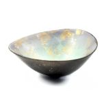 ANNE JAMES (born 1937); a triangular raku dish with lustrous decoration, incised AJ mark, diameter